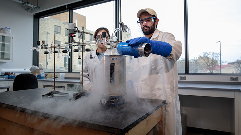 Two students produce a chemical reaction in lab